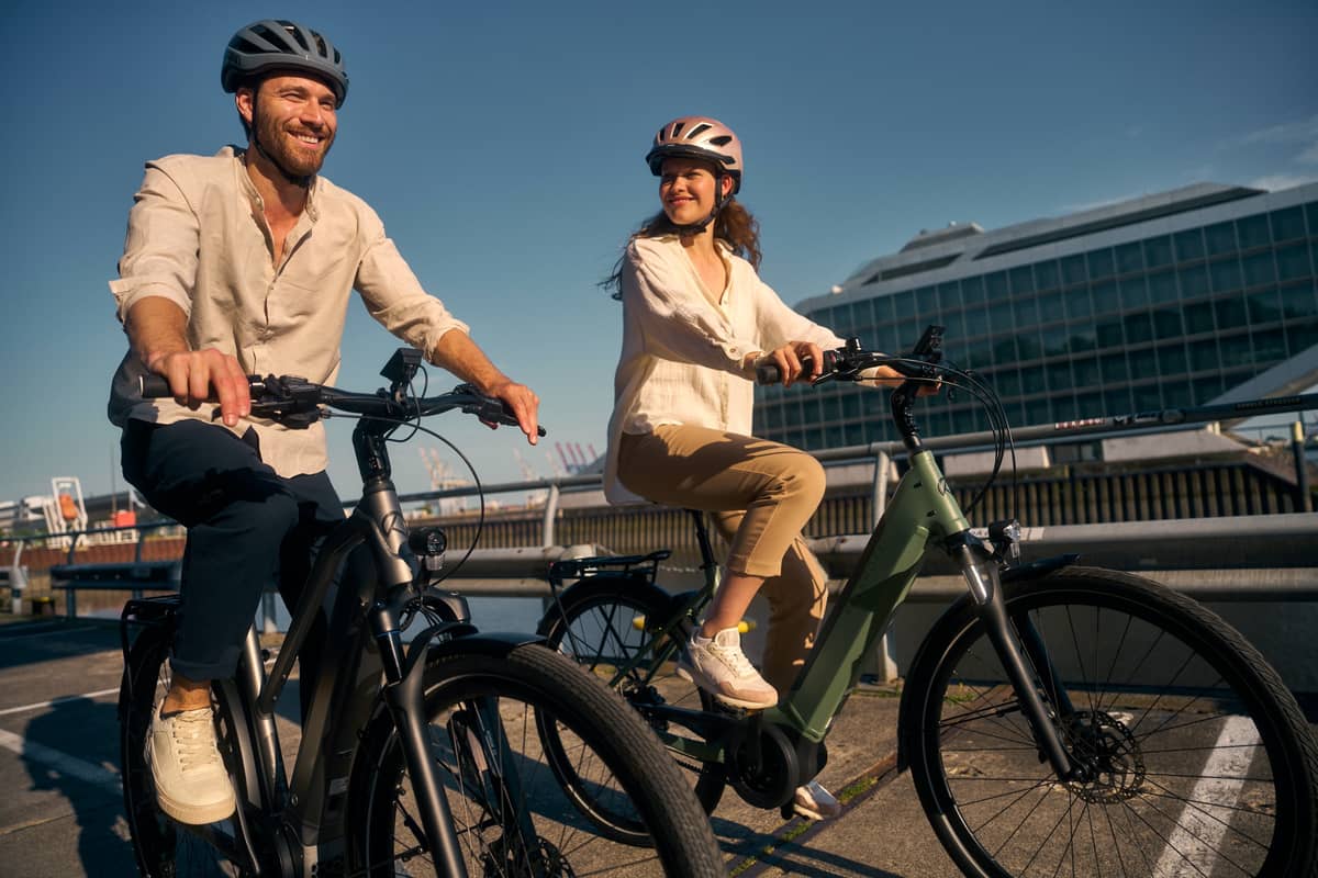 Mann und Frau fahren auf E-Bikes.