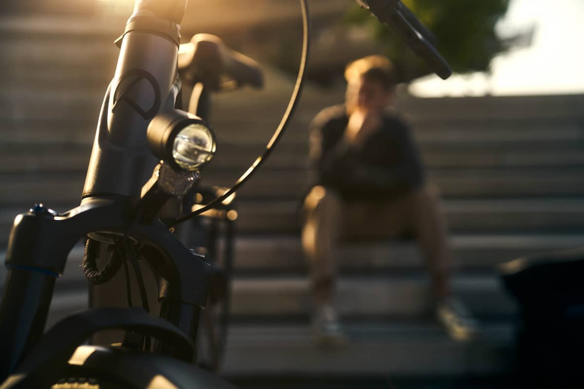 Cyclist with helmet and high-visibility vest in city traffic