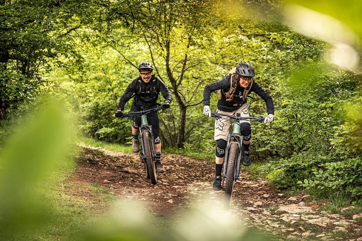 Mann und Frau auf Mountainbikes im Wald