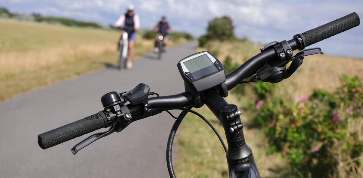 Break at the edge of a cycle path. Close-up of an e-bike handlebar