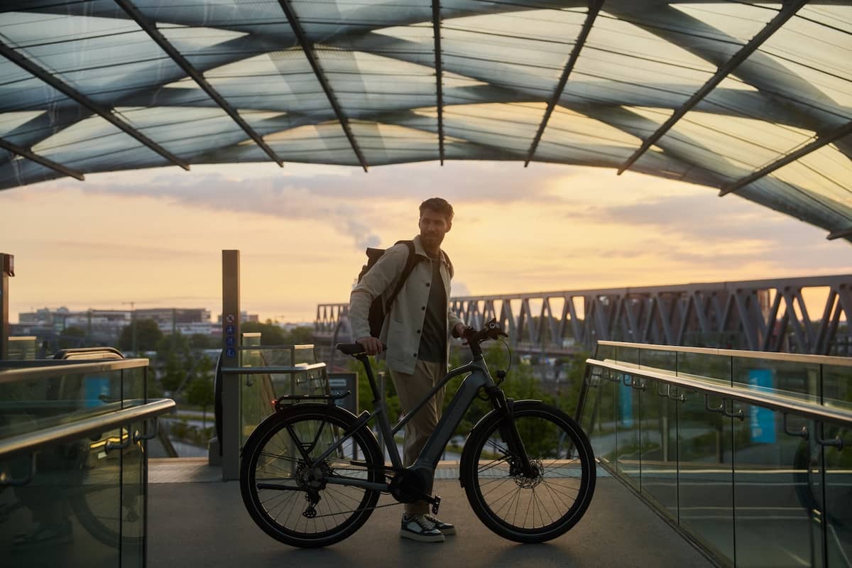 man with Kalkhoff bike standing in front of skyline and looking back