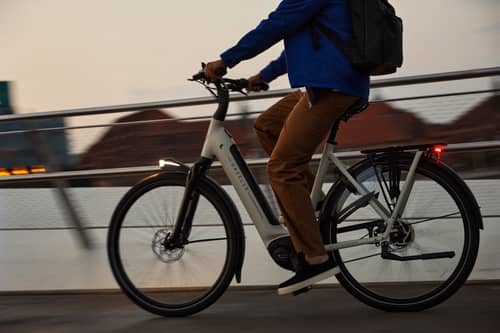 Mann fährt mit E-Bike über Brücke