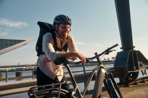 Fahrradhelm und Rucksack lächelt zufrieden