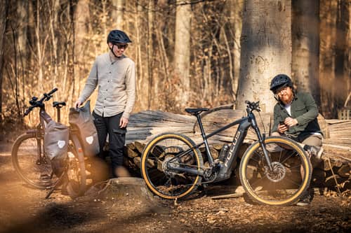 Zwei Männer mit E-Bikes im Wald