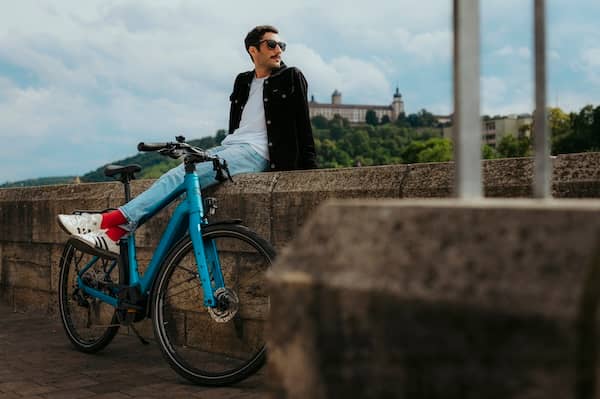 Man sits on e-bike on wall in front of castle