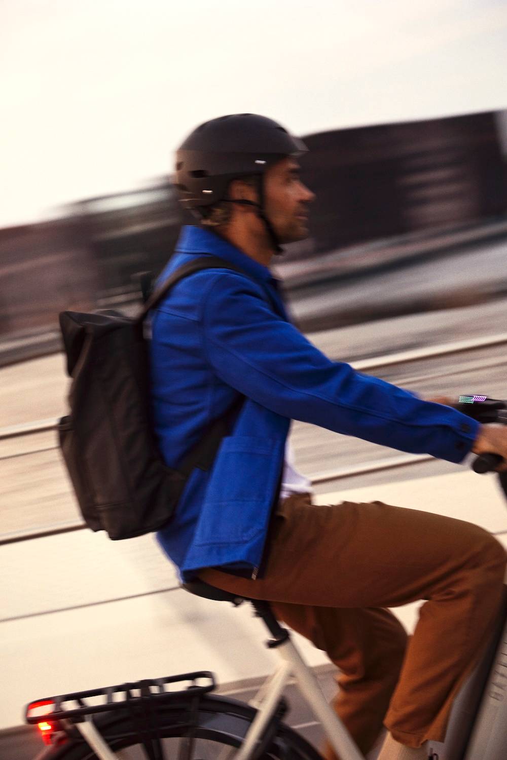 Man with helmet and rucksack on e-bike