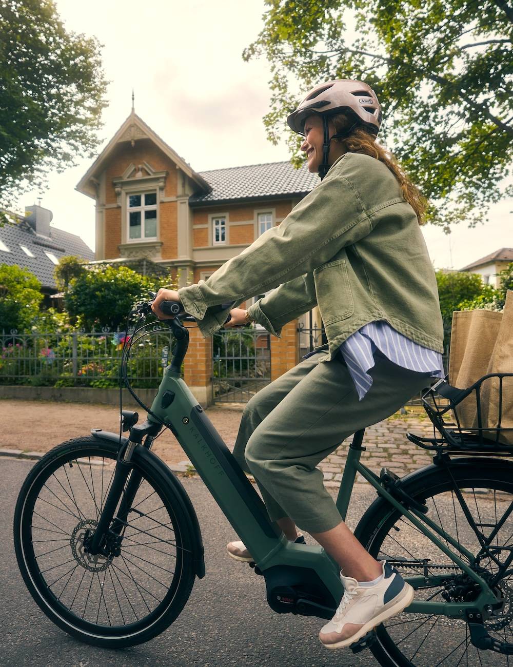 Frau mit E-Bike und Einkäufen