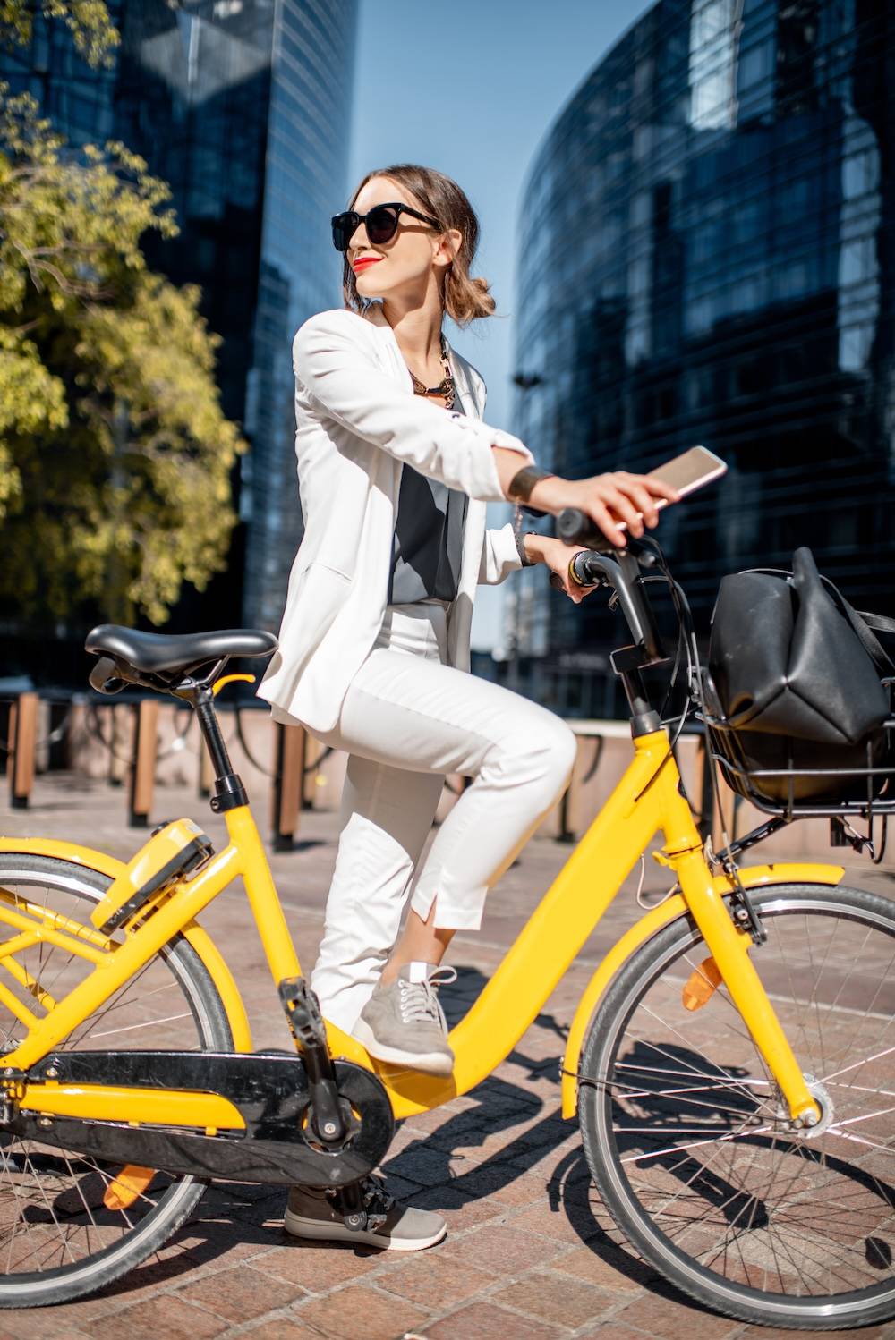 woman with yellow bike in front of skyscrapers