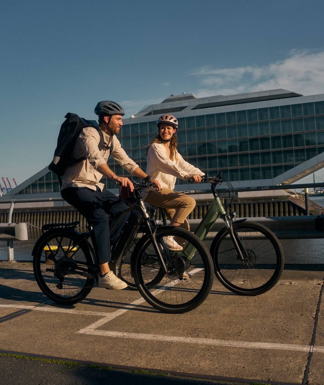 Kalkhoff Bikes Zwei Radfahrer vor Hafenkulisse