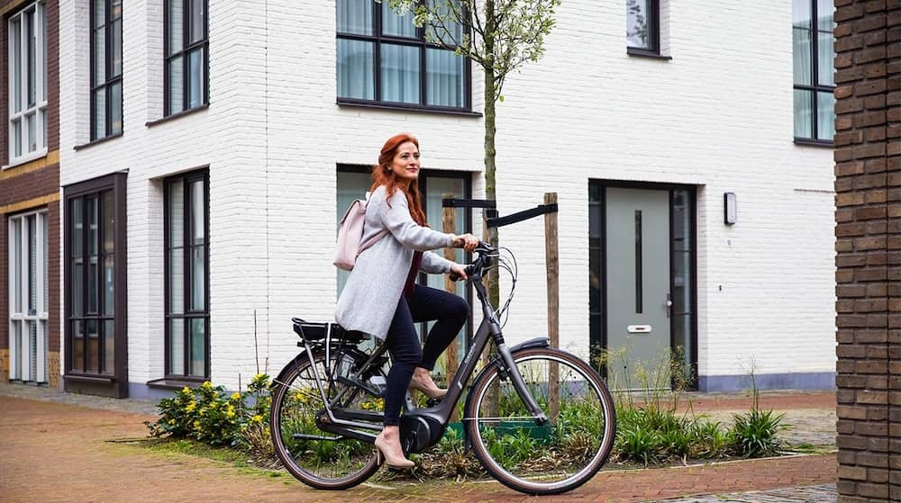 Woman riding an e-bike in the housing estate