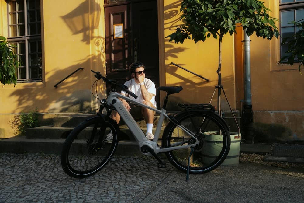 Man sits on stairs behind his e-bike