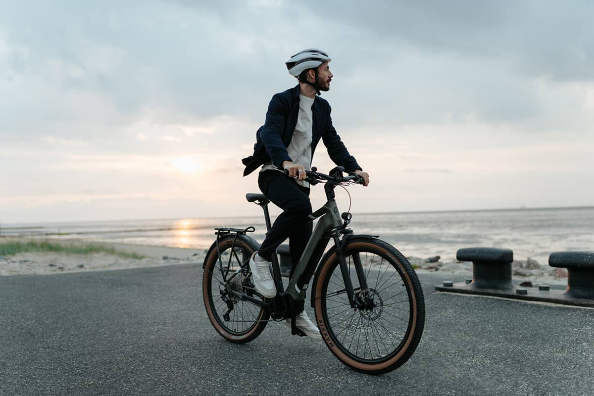 Mann auf Fahrrad nahe des Strandes schaut in den Horizont