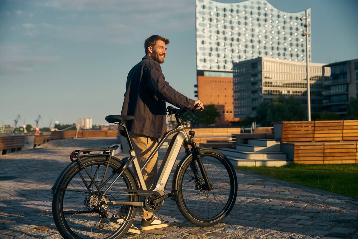 Kalkhoff Bikes Mann steht mit Fahrrad vor Elbphilharmonie