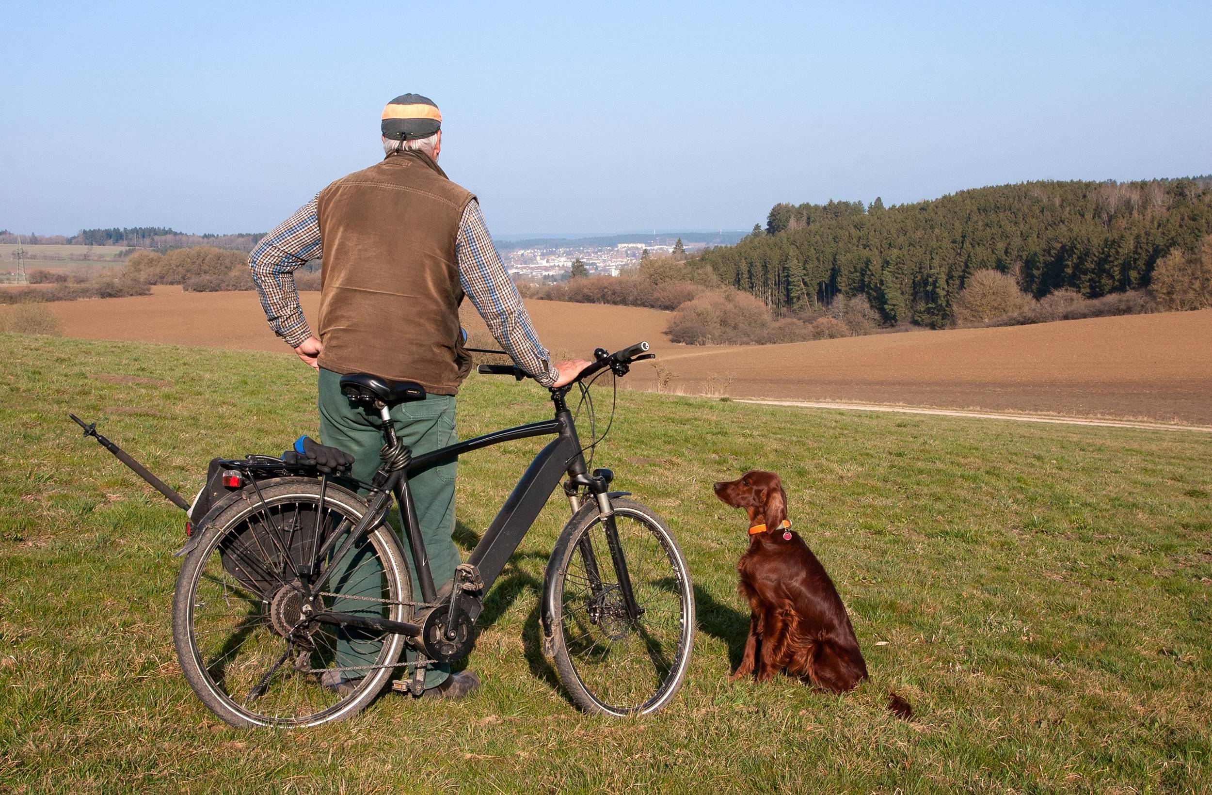 Mann mit E-Bike und Hund in der Natur