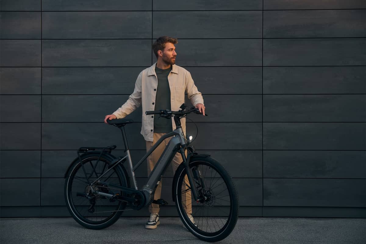 Mann mit Kalkhoff Fahrrad vor dunkler Wand