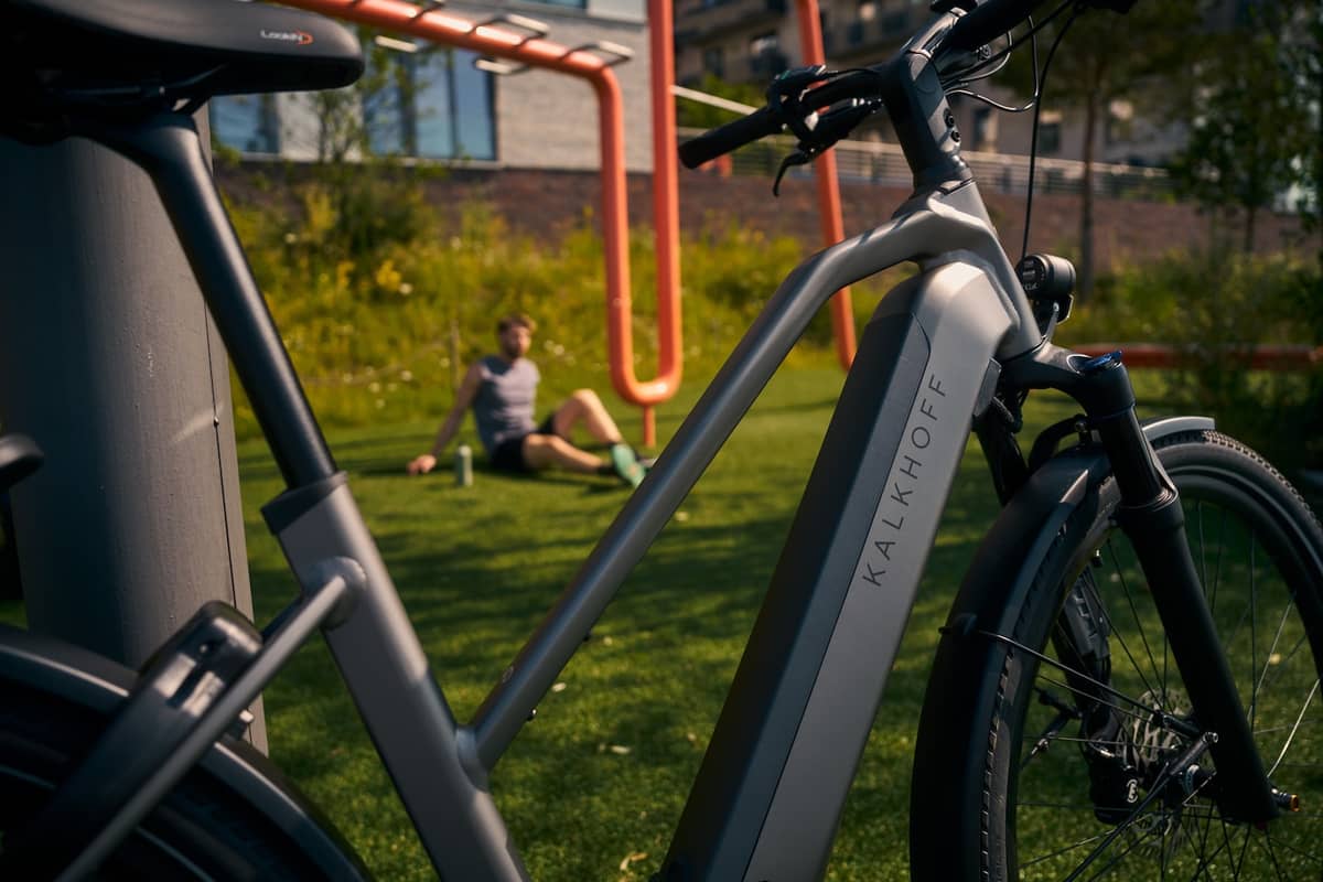 Kalkhoff Fahrrad Detailaufnahme Person bei Sportgeräten im Hintergrund