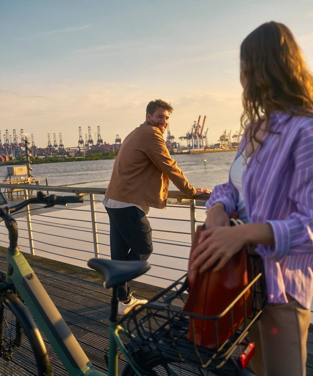 Mann und Frau stehen mit E-Bike an den Landungsbrücken in Hamburg