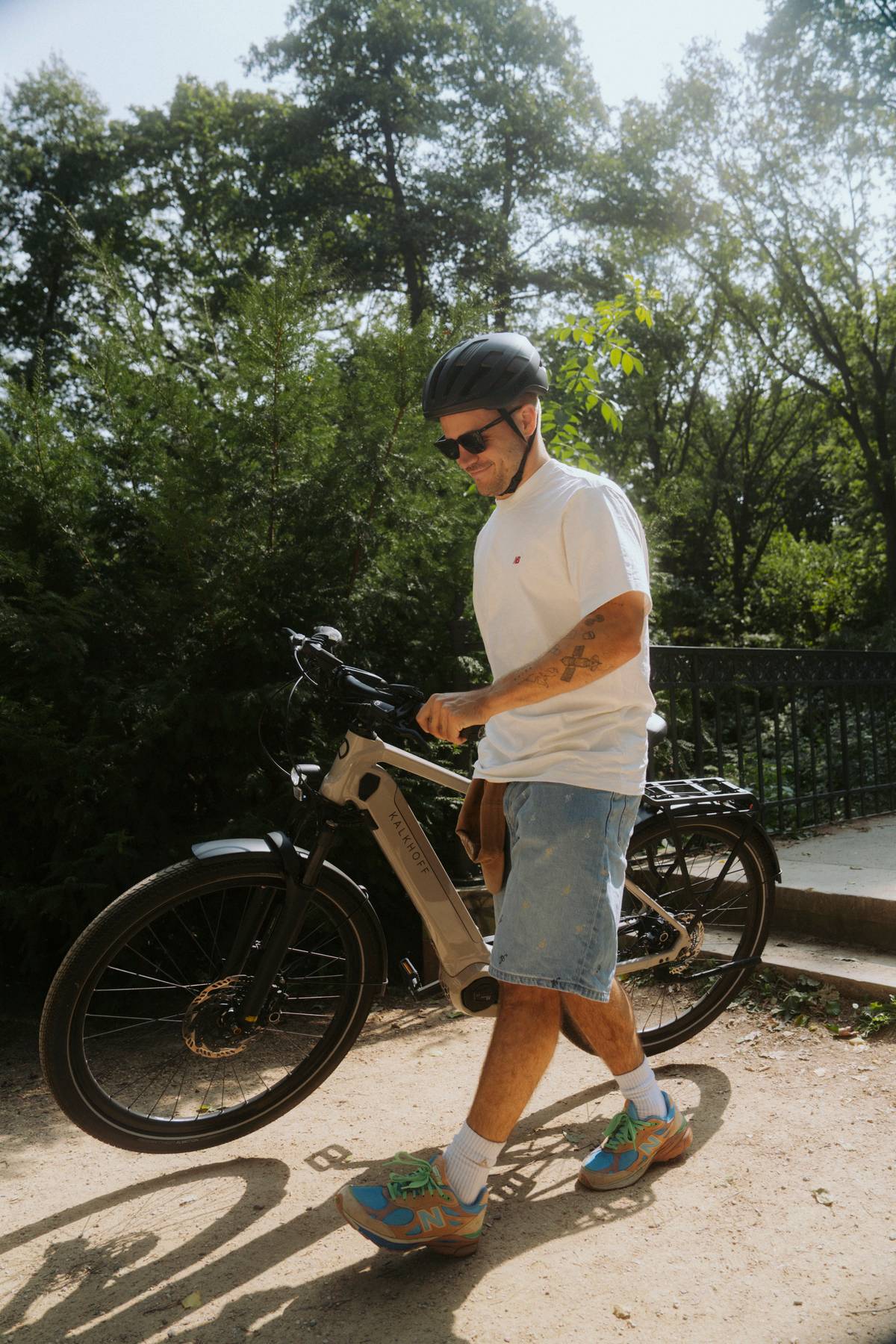 man carrying bike in summer