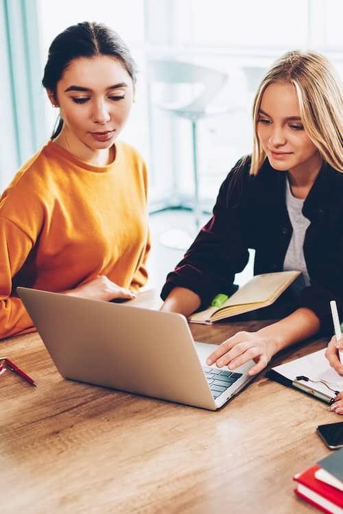 Two young women plan on the computer