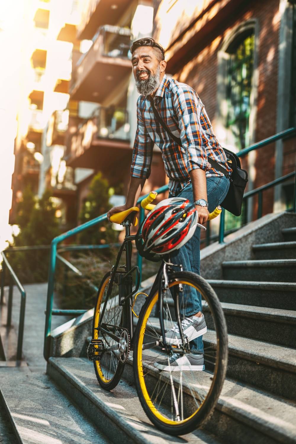 Man with racing bike standing on stairs