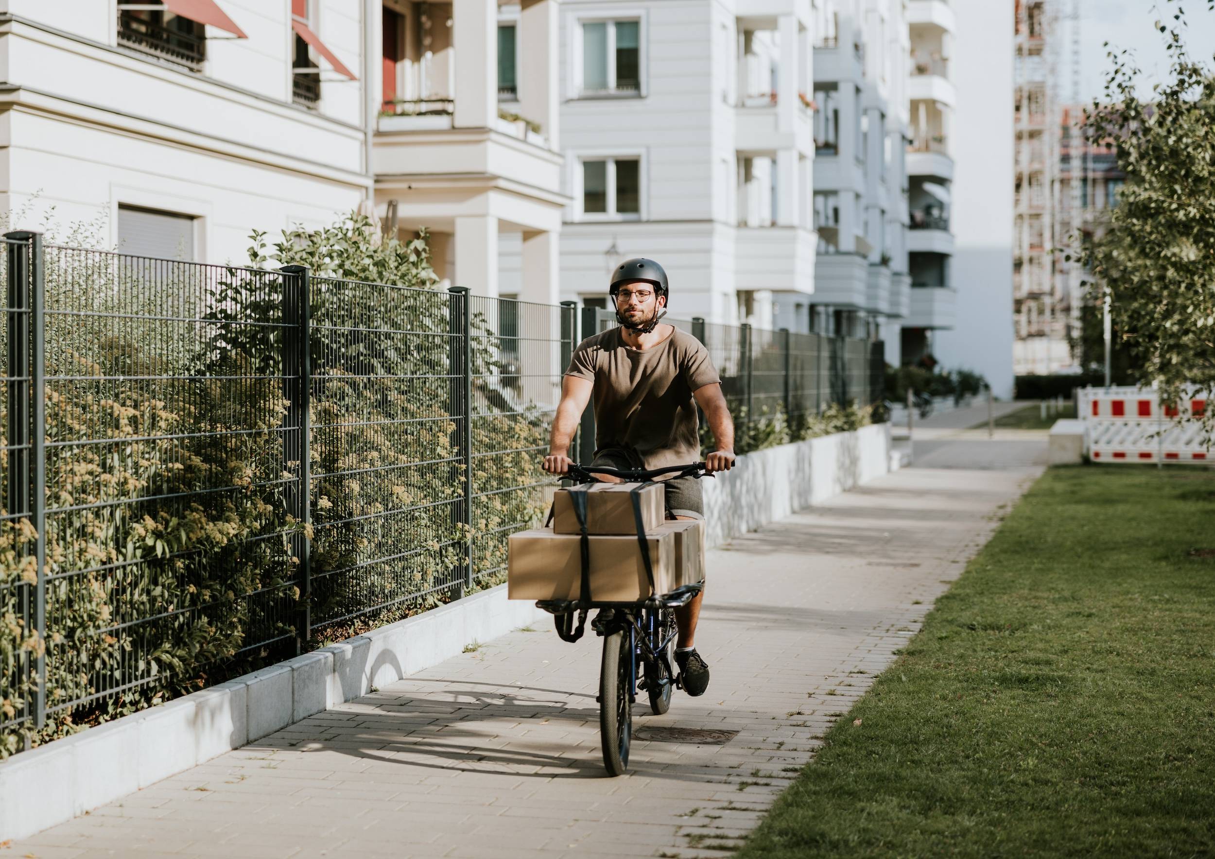 Mann transportiert Pakete mit dem Fahrrad